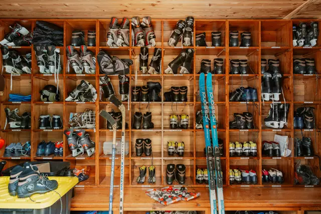 Rental ski boots and skis on a rack